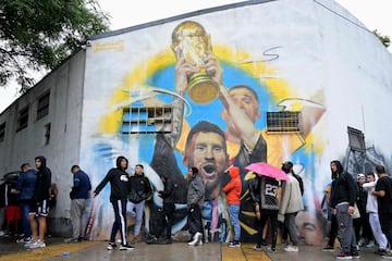 View of a mural painted by Argentine artist Maxi Bagnasco depicting Argentina's forward Lionel Messi holding the FIFA World Cup trophy 