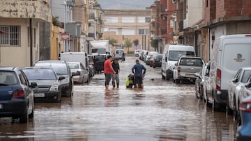 Varias personas observan los estragos ocasionados por la DANA en Llombai, Valencia. El Centro de Coordinación de Emergencias (CCE) ha elevado a rojo el nivel de alerta por lluvias en todo el litoral e interior norte de Valencia.