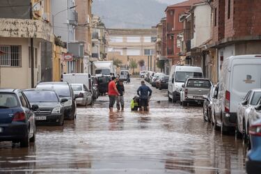 Varias personas observan los estragos ocasionados por la DANA en Llombai, Valencia. El Centro de Coordinación de Emergencias (CCE) ha elevado a rojo el nivel de alerta por lluvias en todo el litoral e interior norte de Valencia.