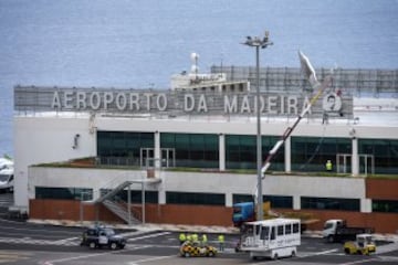 Workers add a sign bearing Cristiano Ronaldo's face to the airport exterior ahead of its 29 March name change to Madeira Cristiano Ronaldo Airport.