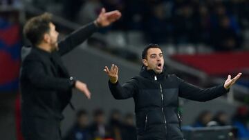 Atletico Madrid's Argentinian coach Diego Simeone (L) and Barcelona's Spanish coach Xavi react during the Spanish league football match between FC Barcelona and Club Atletico de Madrid at the Estadi Olimpic Lluis Companys in Barcelona on December 3, 2023. (Photo by Pau BARRENA / AFP)