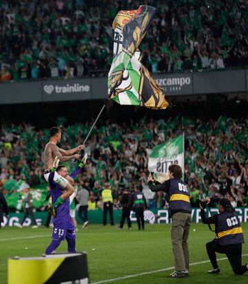 Los jugadores y aficionados del Betis, celebran la victoria ante el Sevilla tras finalizar el partido en el estadio Benito Villamarn.