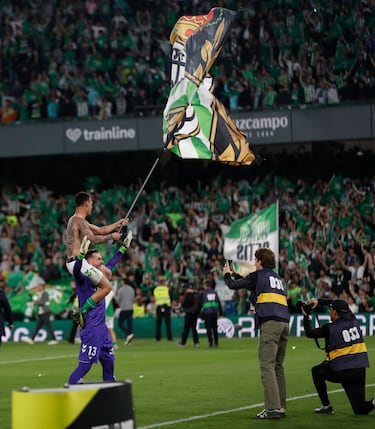 Los jugadores y aficionados del Betis, celebran la victoria ante el Sevilla tras finalizar el partido en el estadio Benito Villamarín.