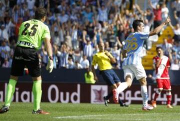 El delantero del Málaga Juan MIguel "Juanmi" (d) celebra su gol, tercero del equipo, ante el poerteo del Rayo Vallecano, Toño Martínez, durante el encuentro de la novena jornada de Liga en Primera División que Málaga y Rayo Vallecano están disputando en el estadio de La Rosaleda, en Málaga.
