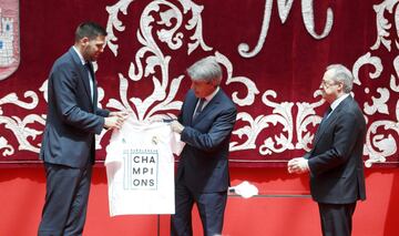 Felipe Reyes entrega una camiseta a Ángel Garrido ante la mirada de Florentino Pérez. 