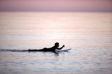 Un hombre practica surf a última hora de la tarde en la playa de Torre de Benagalbón en el Rincón de la Victoria (Málaga), dentro de la nueva normativa que permite hacer actividades deportivas no profesionales en dos franjas horarias.