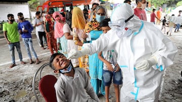 Jammu (India), 25/08/2020.- A paramedic takes a nasal swab sample from a boy in order to conduct a Rapid Antigen test as others stand in queue in Jammu, India, 25 August 2020. India's health authorities reported more than three million positive coron
