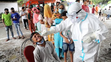 Jammu (India), 25/08/2020.- A paramedic takes a nasal swab sample from a boy in order to conduct a Rapid Antigen test as others stand in queue in Jammu, India, 25 August 2020. India&#039;s health authorities reported more than three million positive coron