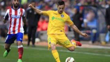 Pablo Sarabia centra ante la mirada de Arda Turan 