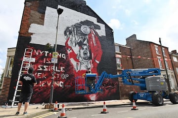 Un artista especialista en graffitis da los últimos retoques en un gran mural en un edificio de viviendas en homenaje al Liverpool. En la imagen, el capitán de los Reds, el centrocampista Jordan Henderson, levanta el trofeo de campeón de la Premier. Henderson, además, ha sido nombrado por la prensa inglesa Jugador del Año. 