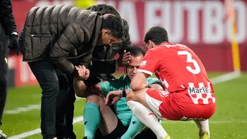 GIRONA, 20/12/2024.- El linier se duele en el suelo tras chocar con Míchel Sánchez (i), entrenador del Girona, durante el partido de la jornada 18 de LaLiga entre el Girona FC y el Real Valladolid CF, este viernes en el estadio Montilivi, en Girona. EFE/David Borrat.