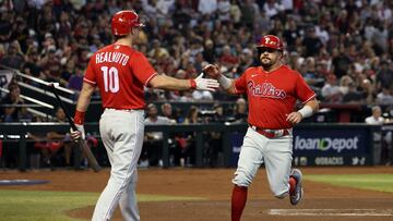PHOENIX, ARIZONA - OCTOBER 21: Kyle Schwarber #12 of the Philadelphia Phillies celebrates with J.T. Realmuto #10 after scoring a run off of a single by Bryson Stott #5 against the Arizona Diamondbacks during the first inning in Game Five of the National League Championship Series at Chase Field on October 21, 2023 in Phoenix, Arizona.   Harry How/Getty Images/AFP (Photo by Harry How / GETTY IMAGES NORTH AMERICA / Getty Images via AFP)