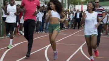 Usain Bolt, plusmarquista mundial de 100, 200 y 4x100 metros, corre con algunas chicas durante un acto promocional en R&iacute;o de Janeiro, donde competir&aacute; sobre 100 metros el domingo. 