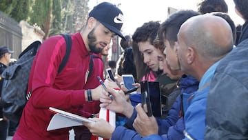 Yannick Carrasco firma autógrafos a los aficionados congregados a las puertas del hotel donde el Atlético de Madrid se alojará en Salamanca.