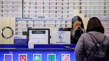 GRAFCVA354. VALENCIA, 12/12/2020.- Una persona adquire loter&iacute;a cuando ya se ven colas en las administraciones m&aacute;s concurridas en las primeras semanas de diciembre, donde las ventas en ventanilla son &quot;pausadas&quot; pero no cesan y suben