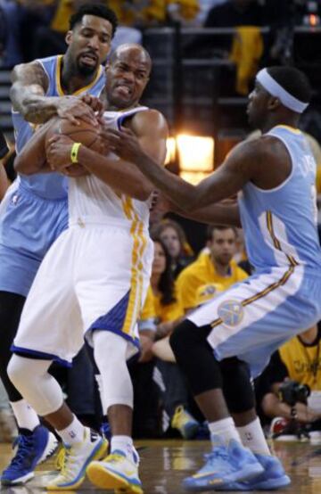 Wilson Chandler y Ty Lawson de los Nuggets contra Warriors Jarrett Jack de losGolden State en el tercer partido de los cuartos de final de la Conferencia Oeste de los Playoffs de la NBA en 2013.