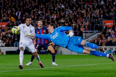 Robert Lewandowski y Militao miran con atención la gran estirada de Thibaut Courtoir para desviar el balón con la mano derecha.