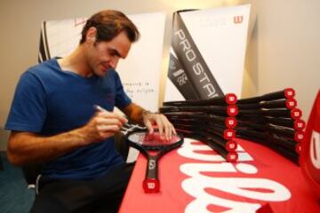 Roger Federer firma sus raquetas conmemorativas por ganar su 18º Grand Slam.