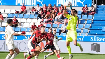 El portero del Deportivo, Germán Parreño, atrapa el balón ante la presencia de Iker Varela.