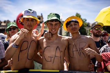 Tres aficionados con el nombre de Pogacar pintado en sus torsos esperan el inicio de la cuarta etapa.