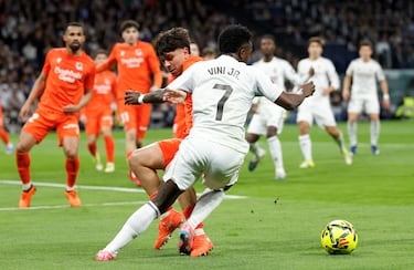 El defensa de la Real Sociedad derriba a Vinicius con su pierna izquierda.