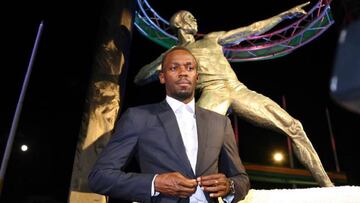 Usain Bolt posa junto a su estatua erigida en el Estadio Nacional de Kingston.