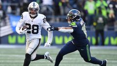 SEATTLE, WASHINGTON - NOVEMBER 27: Josh Jacobs #28 of the Las Vegas Raiders runs with the ball while being chased by Uchenna Nwosu #10 of the Seattle Seahawks in the third quarter at Lumen Field on November 27, 2022 in Seattle, Washington.   Jane Gershovich/Getty Images/AFP (Photo by Jane Gershovich / GETTY IMAGES NORTH AMERICA / Getty Images via AFP)