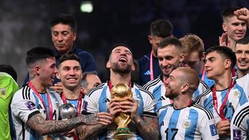 Argentina's defender #19 Nicolas Otamendi holds the FIFA World Cup Trophy as he celebrates with teammates winning the Qatar 2022 World Cup final football match between Argentina and France at Lusail Stadium in Lusail, north of Doha on December 18, 2022. (Photo by Kirill KUDRYAVTSEV / AFP)