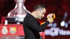 El técnico del FC Barcelona Xavi Hernández se quita la medalla de segundo clasificado tras perder su equipo la final de la Supercopa de España que Real Madrid y FC Barcelona.