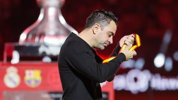 El técnico del FC Barcelona Xavi Hernández se quita la medalla de segundo clasificado tras perder su equipo la final de la Supercopa de España que Real Madrid y FC Barcelona.