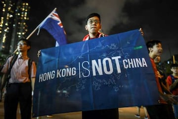 A football fan makes his feelings known while another waves the old British colonial flag after a match in Hong Kong.