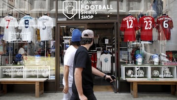 Dos transeúntes se fijan en Classic Football Shirts, la tienda de camisetas de fútbol en la que es posible encontrar cualquier prenda de cualquier equipo y época.