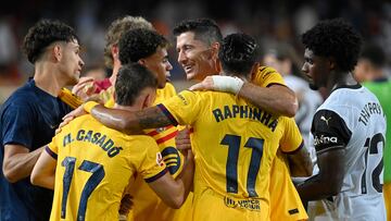 Barcelona's Polish forward #09 Robert Lewandowski (C) celebrates with teammates next to Valencia's Portuguese defender #12 Thierry Correia (R) at the end of the Spanish league football match between Valencia CF and Barcelona at the Mestalla stadium in Valencia on August 17, 2024. (Photo by JOSE JORDAN / AFP)