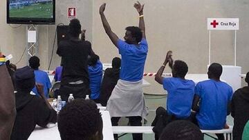 Inmigrantes rescatados en el banco Aquarius ven un partido del Mundial de F&uacute;tbol.