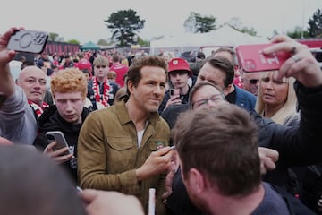 El copropietario del Wrexham, Ryan Reynolds (centro), llega al estadio Racecourse antes del partido. 