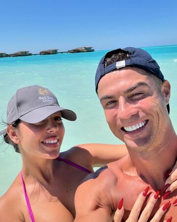 Cristiano Ronaldo y Georgina Rodr¨ªguez posan juntos con parte del resort al fondo.