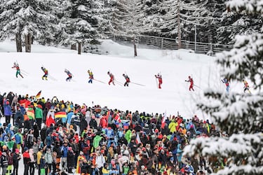 Competidores participan en la prueba de relevos de biatlón masculino de 4 x 7,5 km ante decenas de aficionados. 