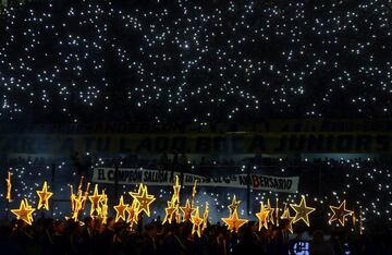 Members of Boca Juniors soccer club hold stars as they wait for the players to come to the field to celebrate after they clinched the Argentine tournament. 