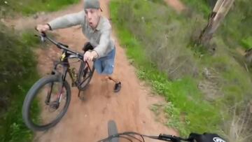Un ciclista a punto de chocar con otro que sube por el sendero en dirección contraria y con cara de sorpresa.