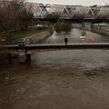 A man looks at the unusually high levels of water of the Manzanares river after weeks of rain in Madrid