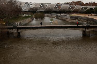 A man looks at the unusually high levels of water of the Manzanares river after weeks of rain in Madrid, Spain, March 20, 2025. REUTERS/Susana Vera