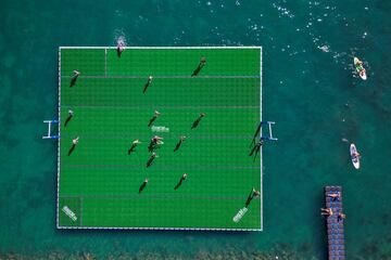 Curiosa fotografía tomada desde el aire en la que se observa a un grupo de jugadores luchando por el balón en un campo de rugby flotante en el lago Lemán durante el Water Rugby Lausanne, un insóilto torneo de tres días organizado por LUC Rugby que reunió a más de 240 jugadores en Lausana, en el oeste de Suiza.