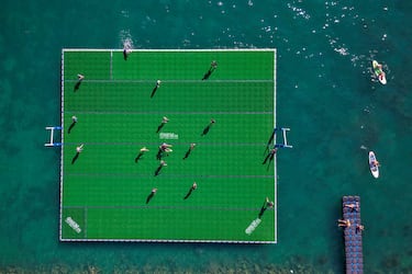 Curiosa fotografía tomada desde el aire en la que se observa a un grupo de jugadores luchando por el balón en un campo de rugby flotante en el lago Lemán durante el Water Rugby Lausanne, un insóilto torneo de tres días organizado por LUC Rugby que reunió a más de 240 jugadores en Lausana, en el oeste de Suiza.