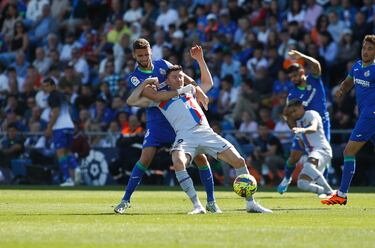 El jugador del Getafe, Domingos, agarra al jugador del Barcelona, Lewandowski. 
 