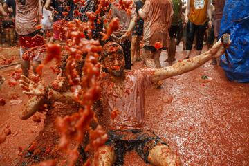 BUNOL, SPAIN - AUGUST 30: Revellers enjoy the atmosphere in tomato pulp while participating the annual Tomatina festival on August 30, 2017 in Bunol, Spain. An estimated 22,000 people threw 150 tons of ripe tomatoes in the world's biggest tomato fight held annually in this Spanish Mediterranean town. (Photo by Pablo Blazquez Dominguez/Getty Images)
