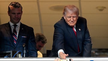 LANDOVER, MARYLAND - NOVEMBER 9: Secretary of War Pete Hegseth (L) watches U.S. President Donald Trump shake the hand of a young fan as he attends the NFL football game between the Detroit Lions and Washington Commanders at Northwest Stadium on November 9, 2025 in Landover, Maryland. Trump attended the game to honor military veterans during halftime of the game. John McDonnell/Getty Images/AFP (Photo by John McDonnell / GETTY IMAGES NORTH AMERICA / Getty Images via AFP)