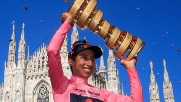 (FILES) In this file photo taken on May 30, 2021, Team Ineos rider Colombia's Egan Bernal celebrates with the race's Trofeo Senza Fine (Endless Trophy) on the podium after winning the Giro d'Italia 2021 cycling race following the 21st and last stage in Milan. - Colombian Egan Bernal is isolating with mild symptoms after contracting Covid-19, less than a week after he won the three-week Giro d'Italia cycling race, his personal communications team said on June 4. (Photo by Luca Bettini / AFP)