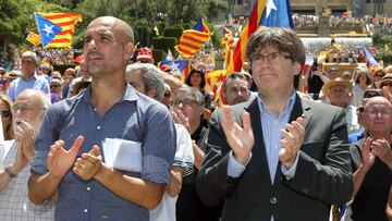 GRA112. BARCELONA, 11/06/2017.- El presidente de la Generalitat, Carles Puigdemont (d), y el exentrenador del FC Barcelona Pep Guardiola aplauden al finallizar un acto con el lema "Referéndum es democracia" convocado por la ANC, Ómnium y la AMI, en el que el mundo soberanista se ha dado hoy cita en Montjuïc, dos días después del anuncio de la fecha y la pregunta de la consulta. EFE/Toni Albir