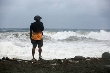 Una persona observa las olas rompiendo en la playa, antes de la llegada del huracán Melissa, en Port Royal, Jamaica.
