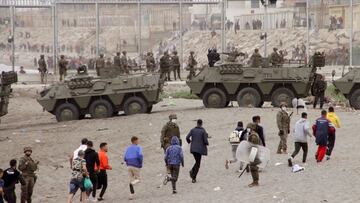 GRAF214. CEUTA, 18/05/2021.- Miembros del Ejército de Tierra dirigen a un grupo de inmigrantes que han logrado cruzar uno de los espigones fronterizos de Ceuta este martes en una avalancha de inmigrantes sin precedentes en España al registrarse la entrada en 24 horas de 5.000 personas (un tercio de ellas menores). EFE/Reduan